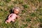 Destroyed old doll missing one leg lies dirty in the grass