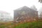 Destruction of the old wooden house, the demolition of dilapidated housing, morning, all in dense fog