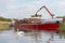 Destruction of the swans â€™natural habitat. Destruction of nature unloading timber logs from a ship by crane at the Danube