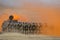 Detachment of Russian paratroopers runs for an armored car across the field in protective orange smoke