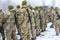 A detachment of soldiers with Kalashnikov assault rifles stand in formation to prepare for battle and offensive