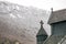 Detail of 1000 year old intricate stave church in Norway with snow-covered mountain in background