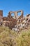 Detail of abandoned building in ghost town with stone walls and shrubs in desert