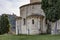 Detail of the apse of the Sant`Antimo Abbey with in the background the village of Castelnuovo dell`Abate, Siena, Tuscany, Italy