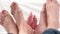 Detail of baby and parents feet, soles dancing, conceptual, the most secure love