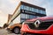 The detail of badge and frontal part of red Renault Captur SUV in front of the Dacia - Renault dealership which sells these