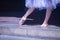 Detail of bare feet of ballerina exercising on the floor under a white tutu