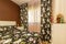 Detail of a bedroom with white bookshelves and a loud bedspread with matching curtains