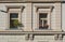 Detail of beige facade of old prague tenement house Windows with flower boxes