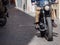 Detail of a Black Motorcycle Seen from the Frontside on a City Road with Cobblestone in Italy