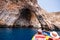 A Detail of Blue Grotto with a boat of tourists visiting (Malta
