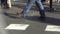 Detail of blurred feet walking toward the left in a pedestrian crossing.Slow Motion