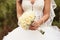 Detail of bride\'s roses bouquet and hands holding