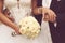 Detail of bride\'s roses bouquet and hands holding