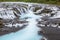 Detail of bright powerful Bruarfoss waterfall in Iceland with cyan water.