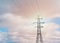 Detail of a British Style Electricity Pylon and suspended electric cables against  Blue Cloudy Sky