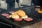 Detail of chef preparing delicious burgers on outdoor barbeque.