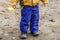 Detail of child legs in overalls - boy in workwear