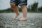 Detail of the children`s dirty legs of running baby, wearing denim shorts taken from the low angle