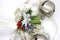 Detail of Christmas decoration with white ribbon and gold details. Silver angel christmas decoration with green details and red be