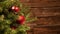 Detail of a christmas tree with red glitter balls in front of a wooden wall