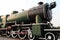 A detail closeup of a steam locomotive releasing steam. Vintage train.