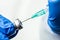 Detail closeup of syringe needle in ampoule vial,UK nurse taking injection shot