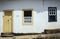 Detail of a colonial house in Tiradentes, Brazil, with boy looking out from one window.