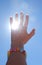 Detail color photography of womans hand catching sun rays and blue sky