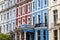 Detail of colourful terraced townhouses. The area of Notting Hill, London, is famous for streets of houses with brightly painted