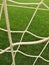 Detail of crossed soccer nets, soccer football in goal net with plastic grass on football playground
