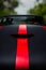 Detail of a dark racing sport car with bonnet scoop vent and red stripes