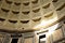 Detail of decorated concrete Dome of the Pantheon, Rome, Italy with beam of sunlight shining through the central opening (oculus)