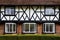 detail of diamond-paned windows on a front gable of a tudor property