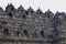 Detail of exterior wall of ancient Borobudur temple with meditating Buddha statues