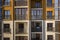 Detail exterior wall of apartment or office building. Forged balcony railing, blue sky reflected in shiny mirror windows.