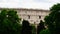 Detail of the facade with arches of the Colosseum Amphitheatrum Flavium with trees in front