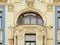 Detail of facade of Art deco buillding , oval window with with faces and abstract decorations