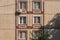 Detail of facade of a shabby multistory prefabricated concrete house, lined with ceramic glossy tiles with vertical row of windows