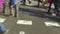 Detail of feet passing through a pedestrian crossing.