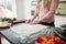 Detail of female hands making pizza from dough.