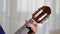 Detail of female hands tuning an acoustic guitar moving the pegs at home