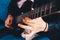 Detail of the fingers of a guitarist playing a chord on an electric guitar