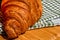 Detail of fresh croissant on wooden table. Food and breakfast concept. Close up photo of French buttery croissant