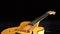 Detail of frets, string, body, mouth and bridge of typical classic spanish guitar rotating in black background