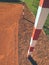 Detail of gate frame . Football or handball playground, light red clay. Red crushed bricks surface on ground