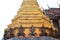 Detail of the golden chedi with the supporting giants around the base, , Wat Phra Kaew, Bangkok, Thailand