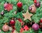 Detail of green Christmas (Chrismas) tree with colored ornaments, globes, stars, Santa Claus, Snowman