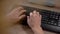 Detail on a hand controlling a computer using a keyboard and a mouse