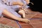 Detail of hands of a ballet dancer putting on and fastening her pink ballet shoes. Concept dance and classical ballet